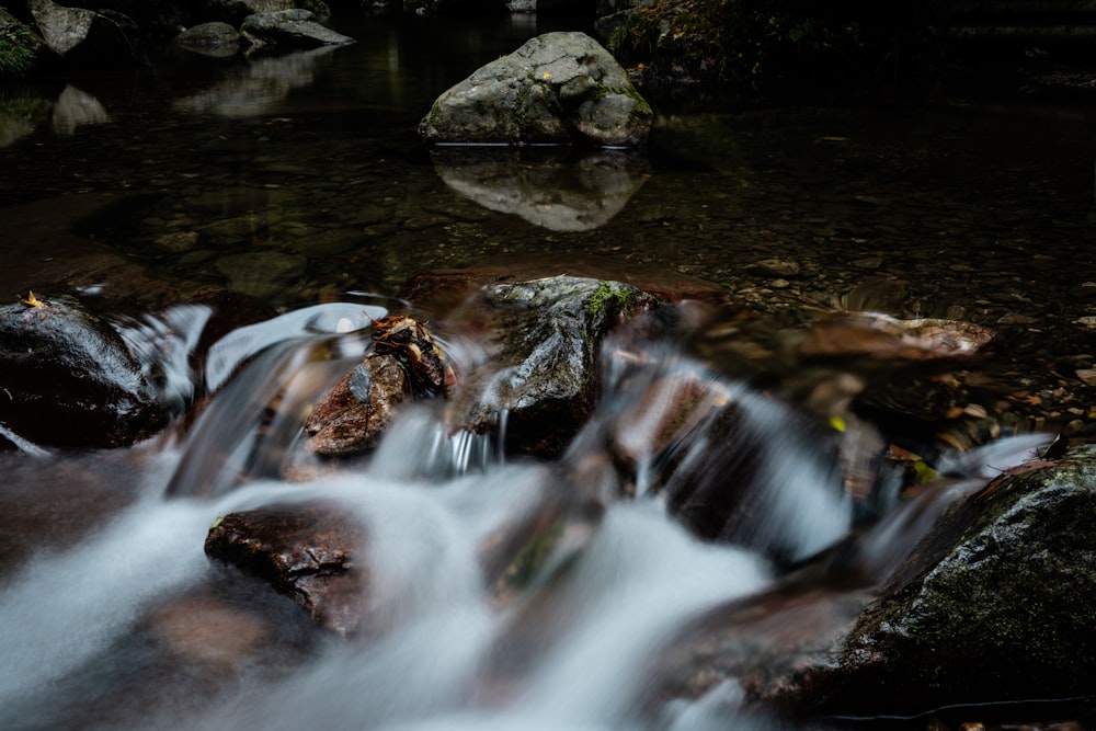 a stream of water running over rocks in a forest