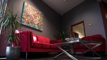 a living room with a red couch and a coffee table