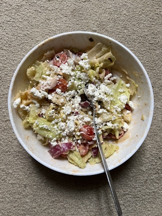 A colorful bowl of mixed salad with cherry tomatoes, lettuce, and olives.