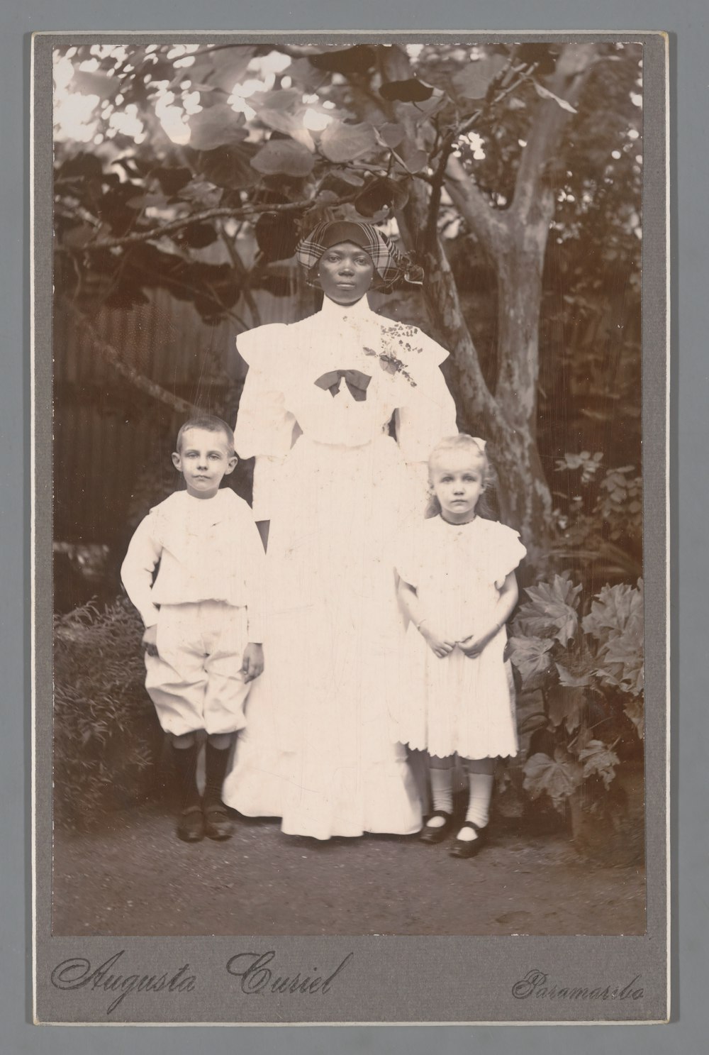 an old photo of a woman and two children