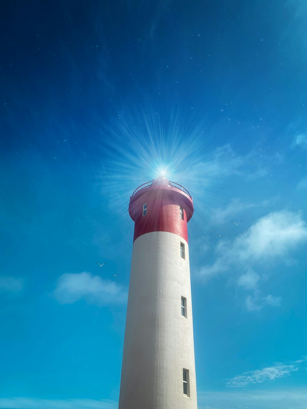 Ein rot-weißer Leuchtturm unter blauem Himmel