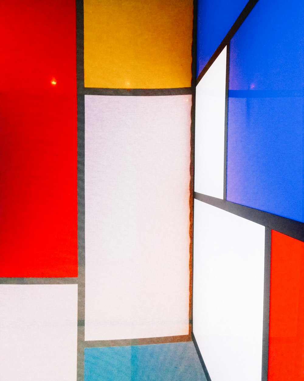 a multicolored room with a red, yellow, blue, and white wall