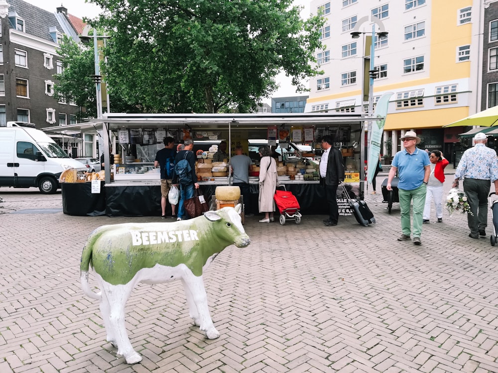 a statue of a cow on a brick street