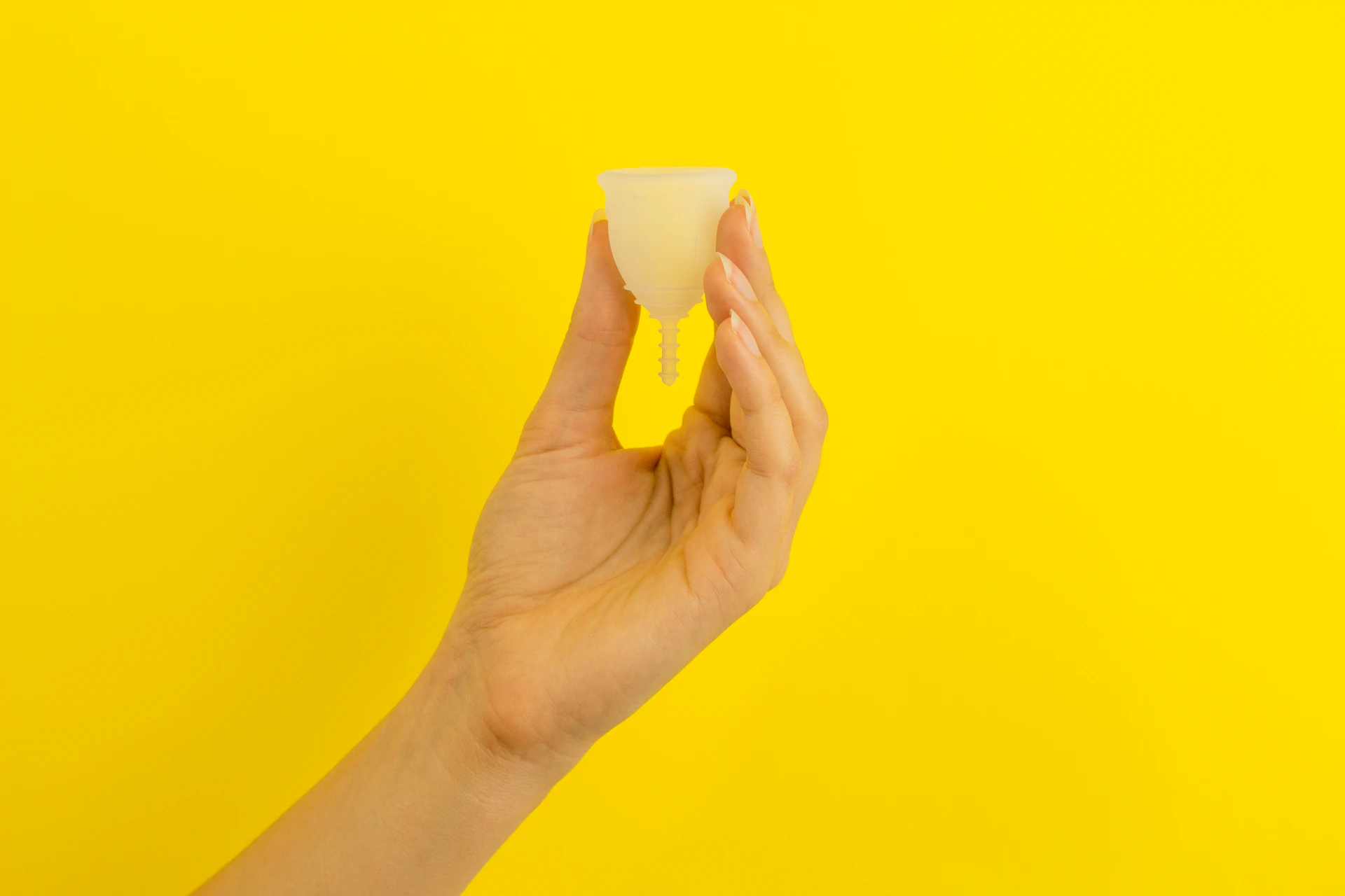 a hand holding a piece of food over a yellow background