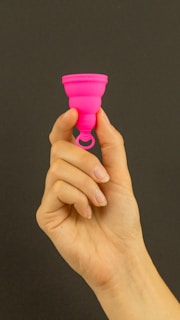 a person holding a pink cup in their hand