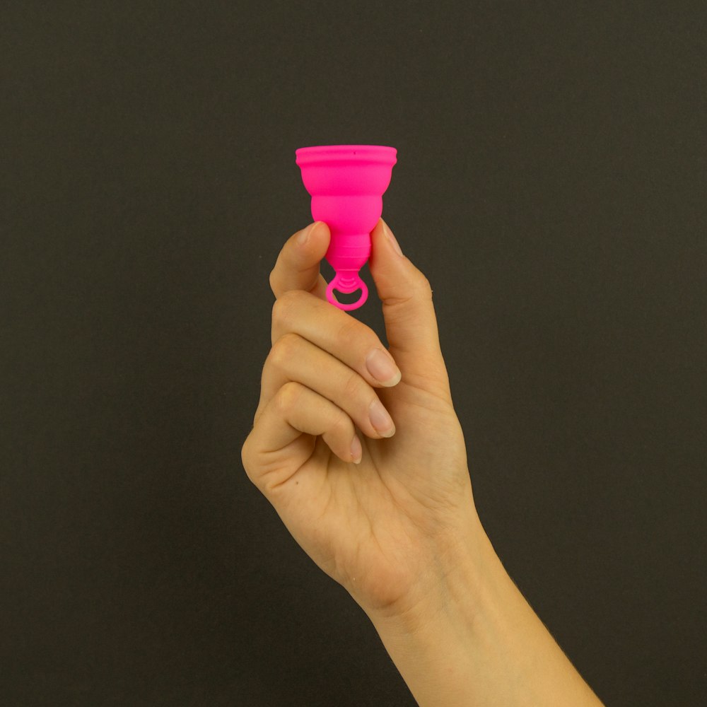 a person holding a pink cup in their hand