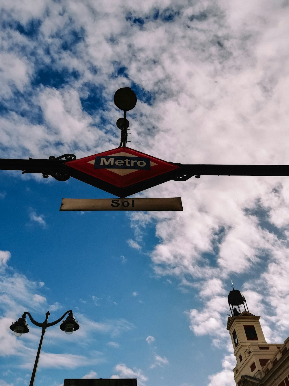 a red metro sign hanging from the side of a building