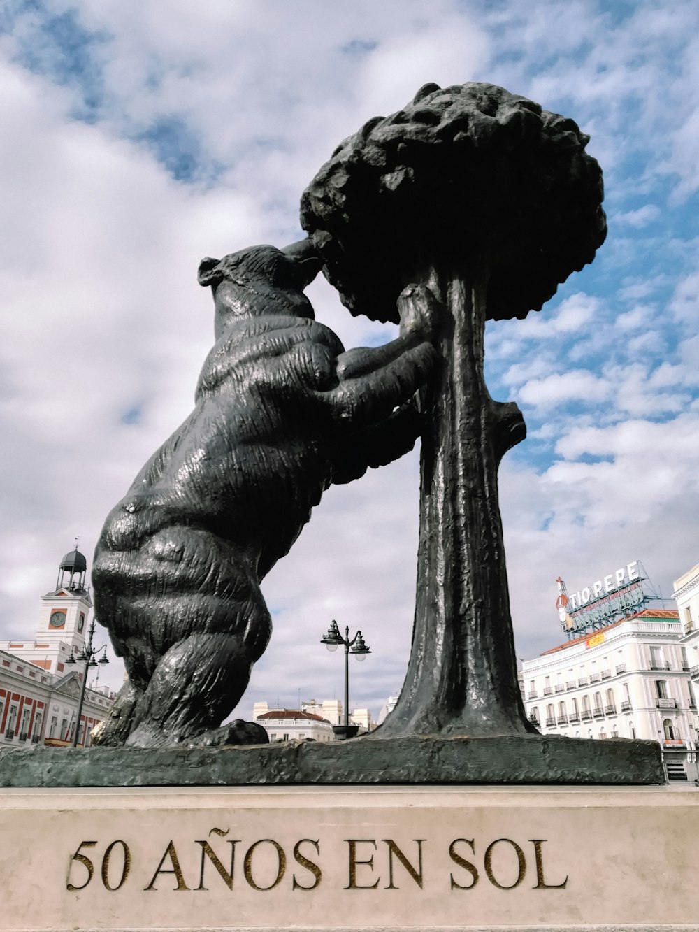 a statue of a bear holding onto a tree