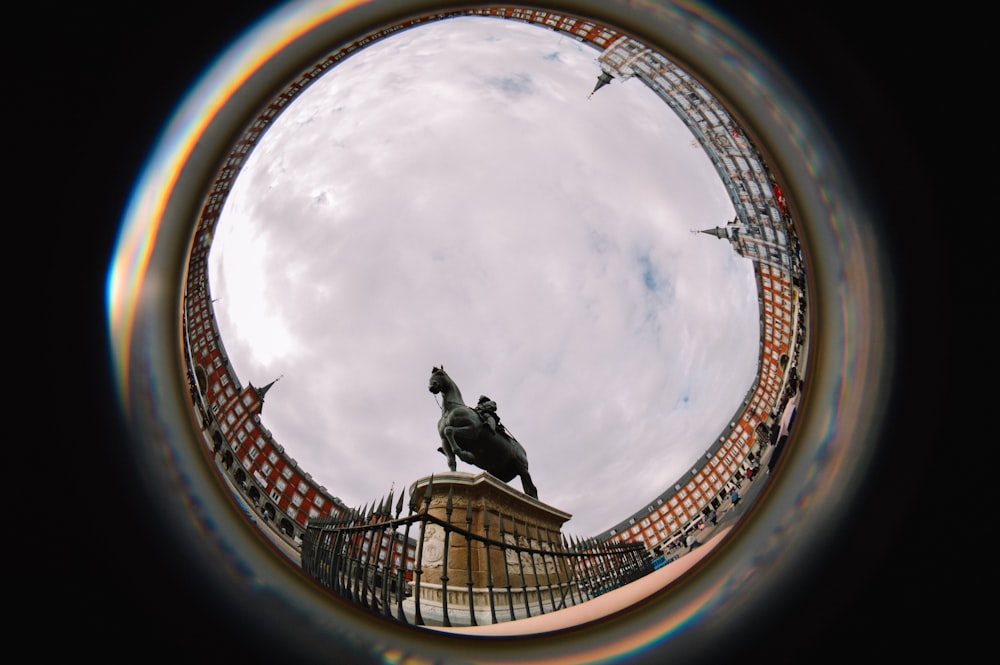 a fish eye view of a statue on top of a building