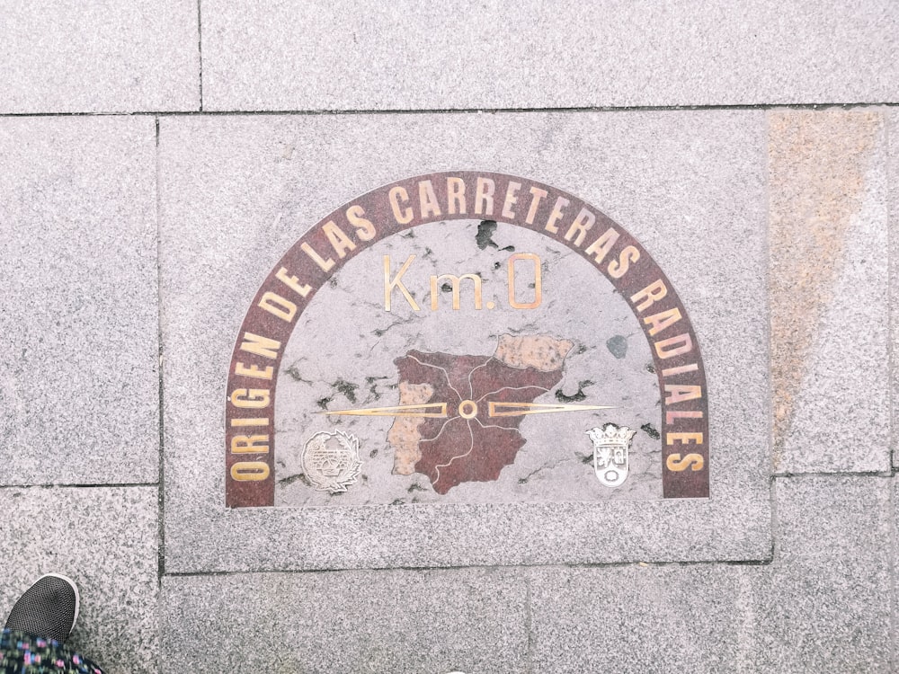 a person standing in front of a wall with a plaque on it