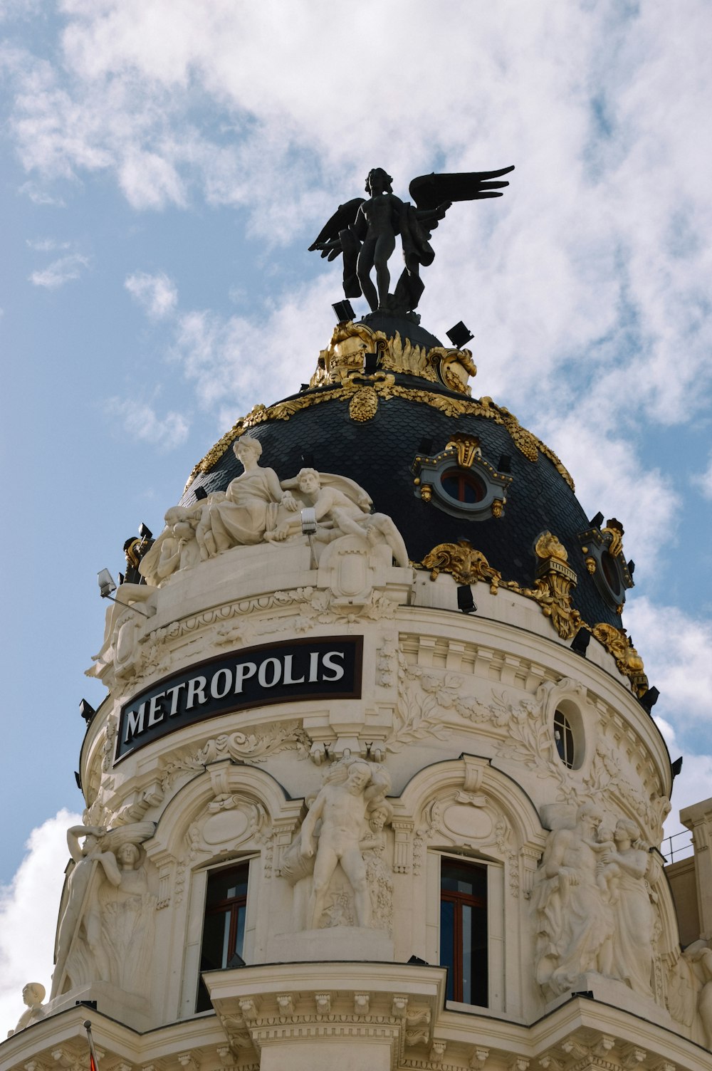 a statue on top of a building with a sky background