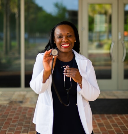A smiling doctor holding a stethoscope in a clinic.