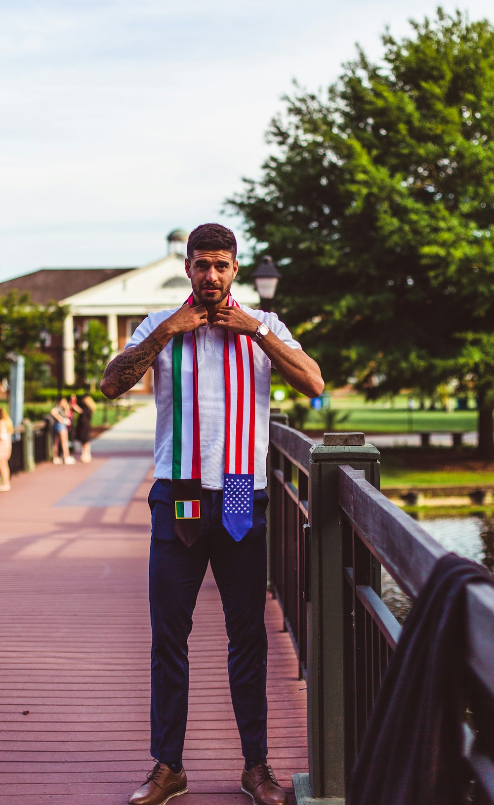 a man standing on a bridge with a tie around his neck