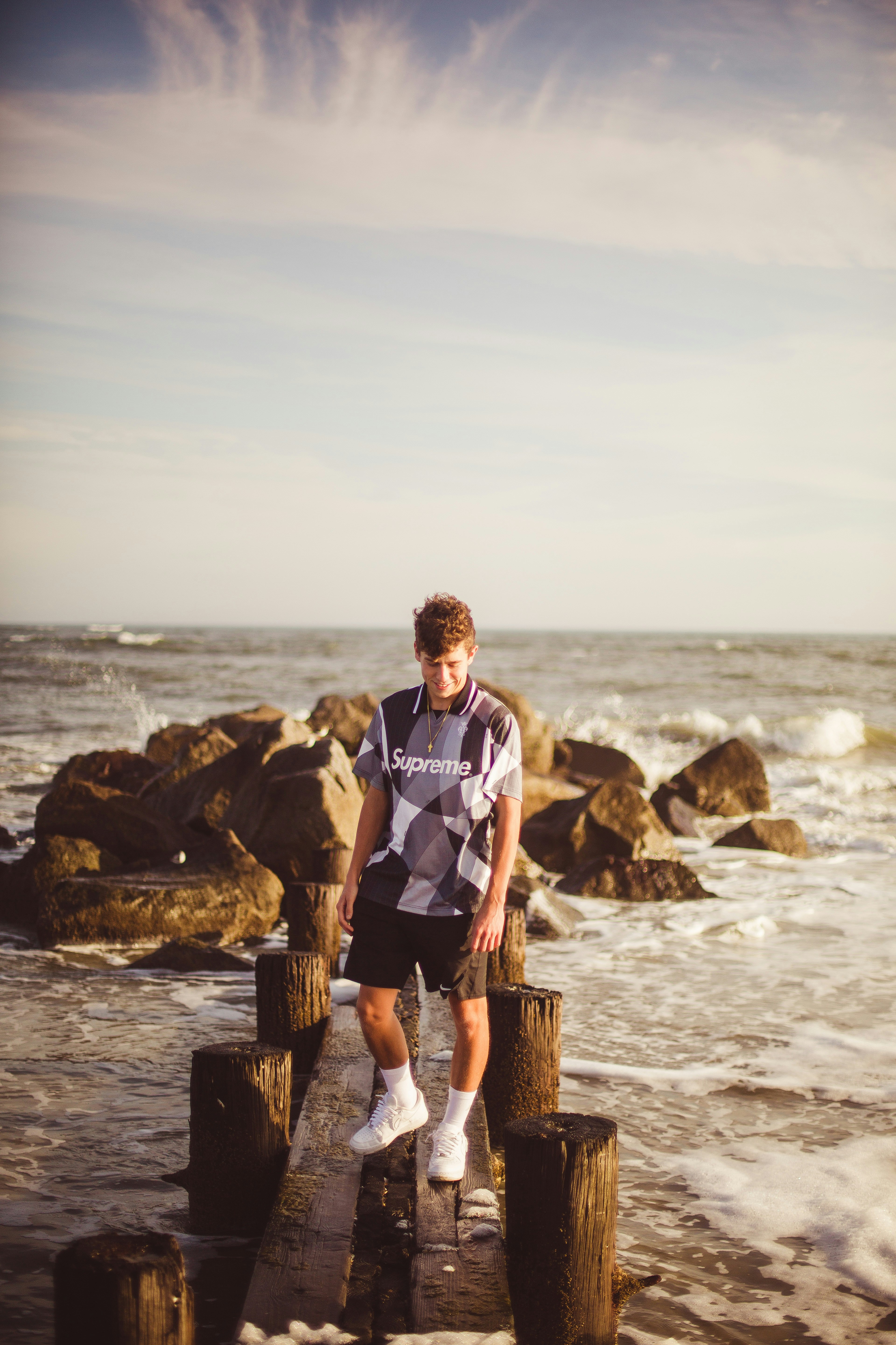 Un hombre parado en un muelle de madera junto al océano