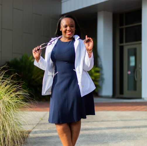 a woman in a blue dress and white jacket