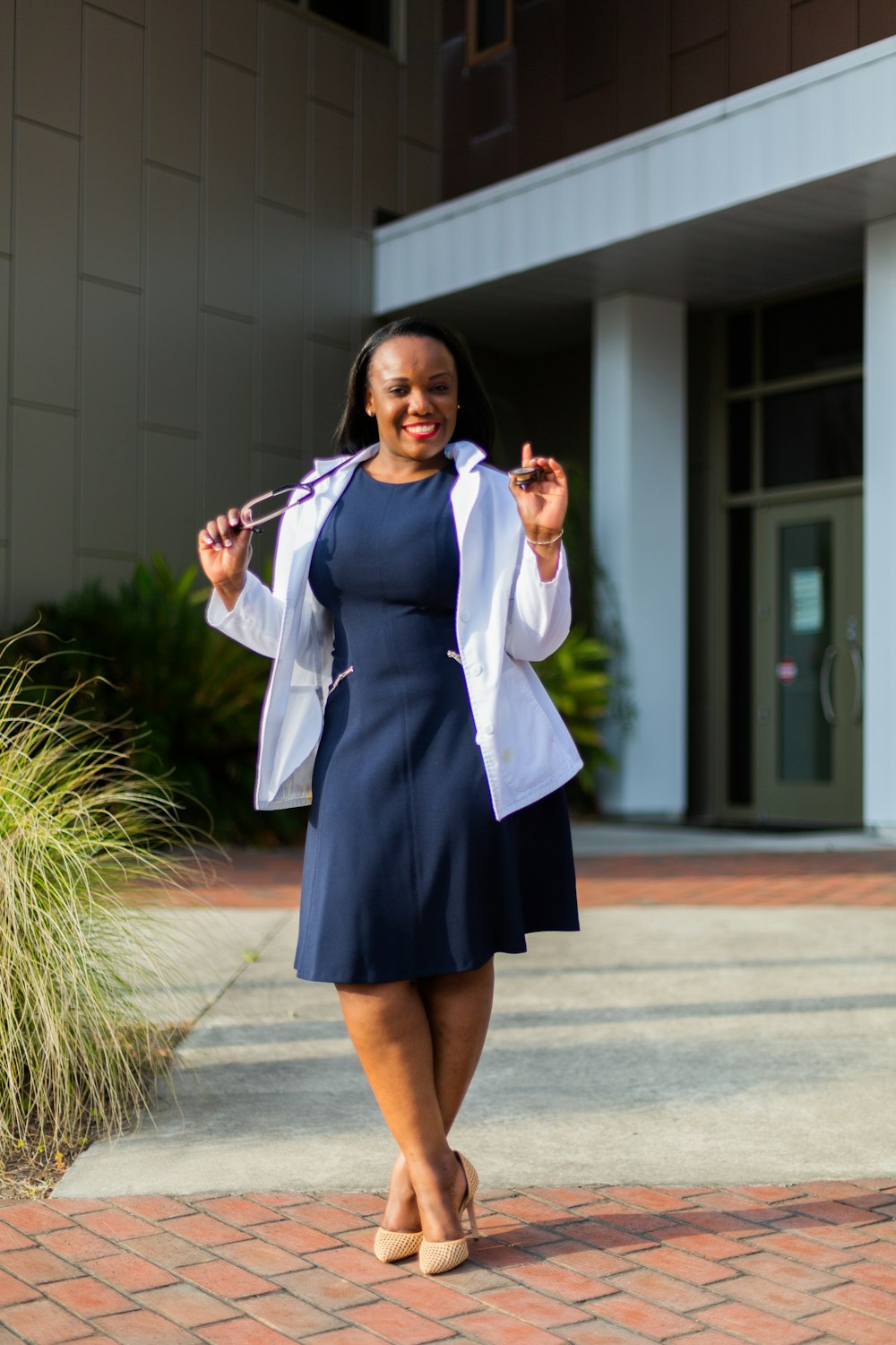 a woman in a blue dress and white jacket