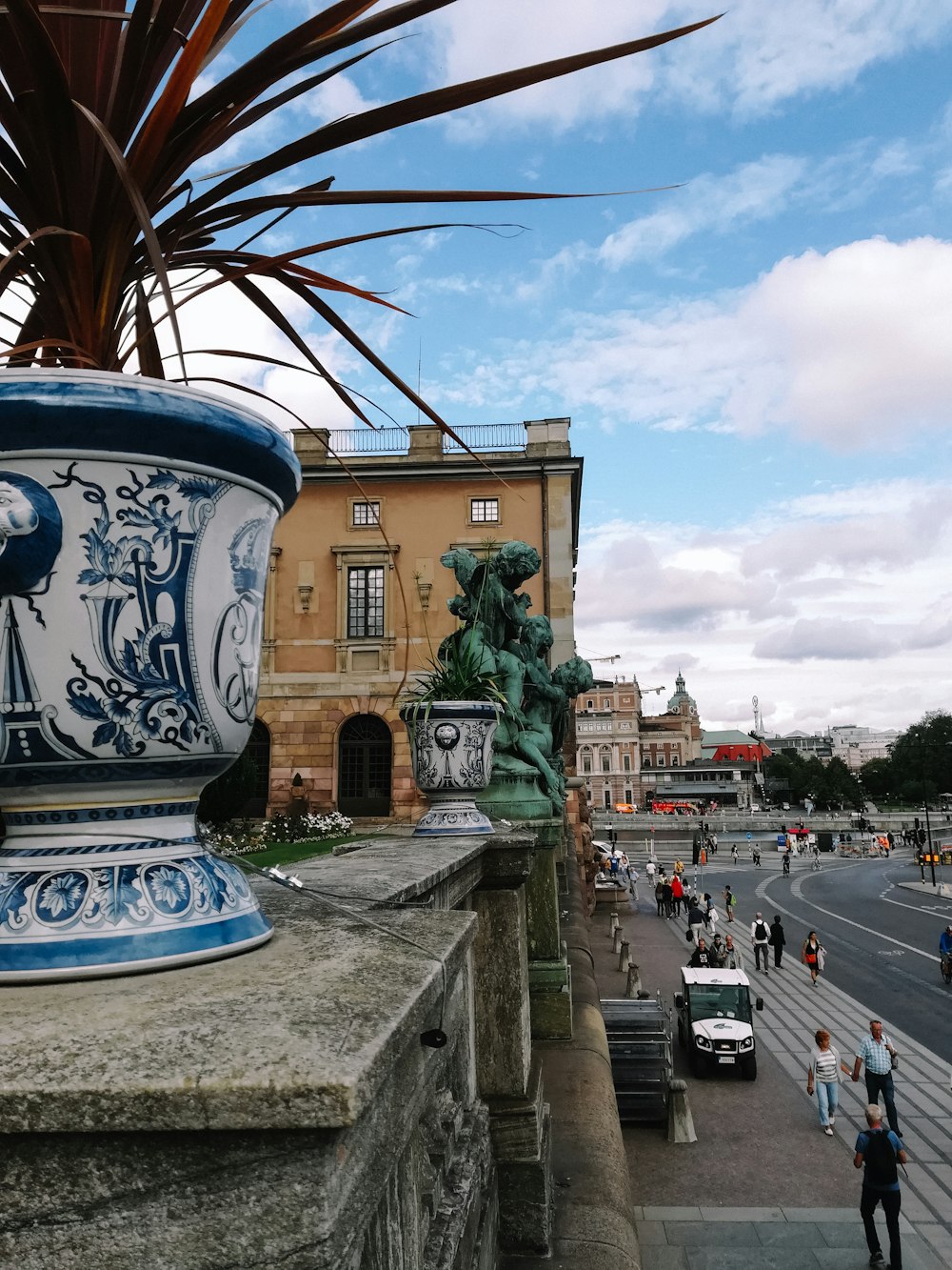 a large blue and white vase sitting on the side of a building