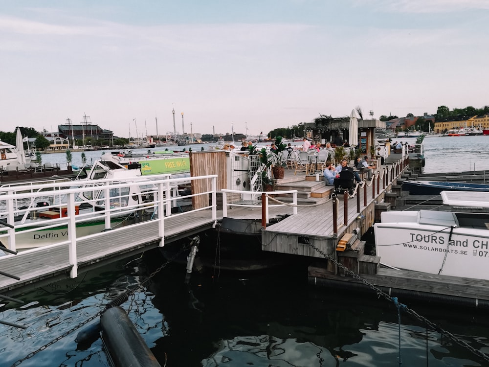 a group of people standing on a dock next to boats