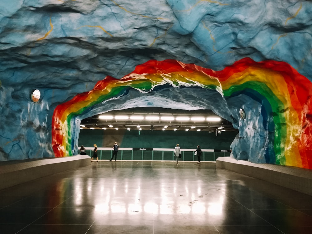 a rainbow painted tunnel in a subway station