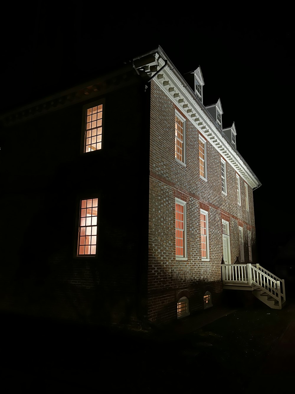 a brick building with three windows at night