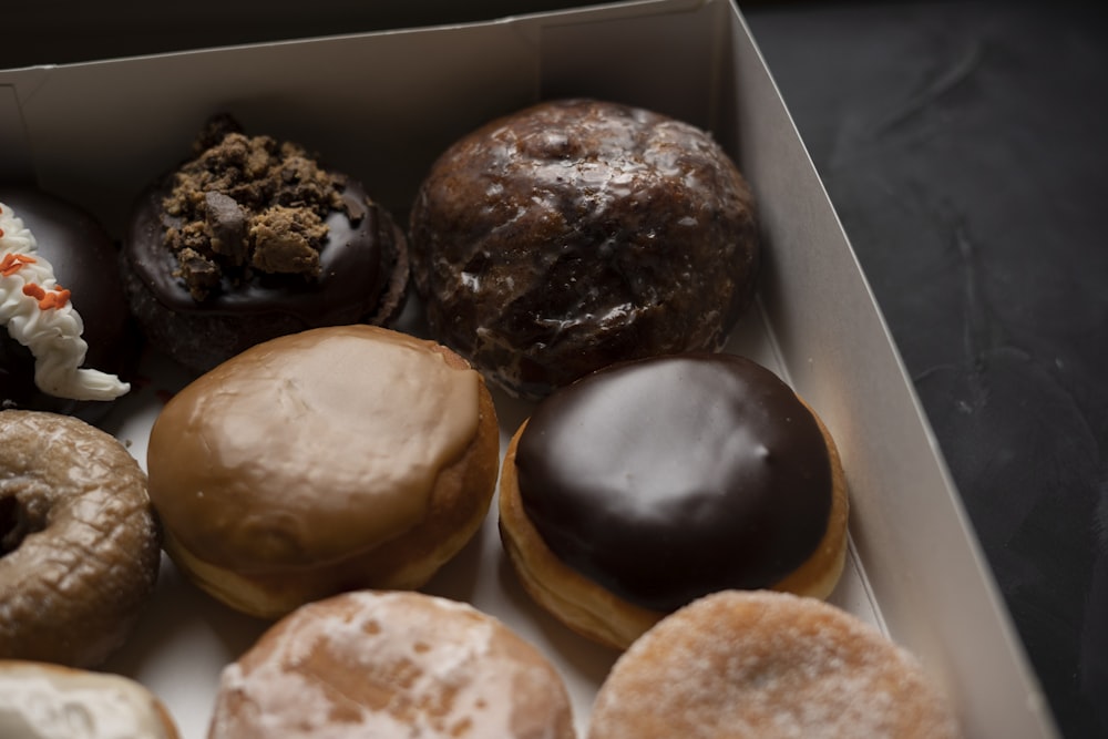 a box filled with lots of different flavored donuts