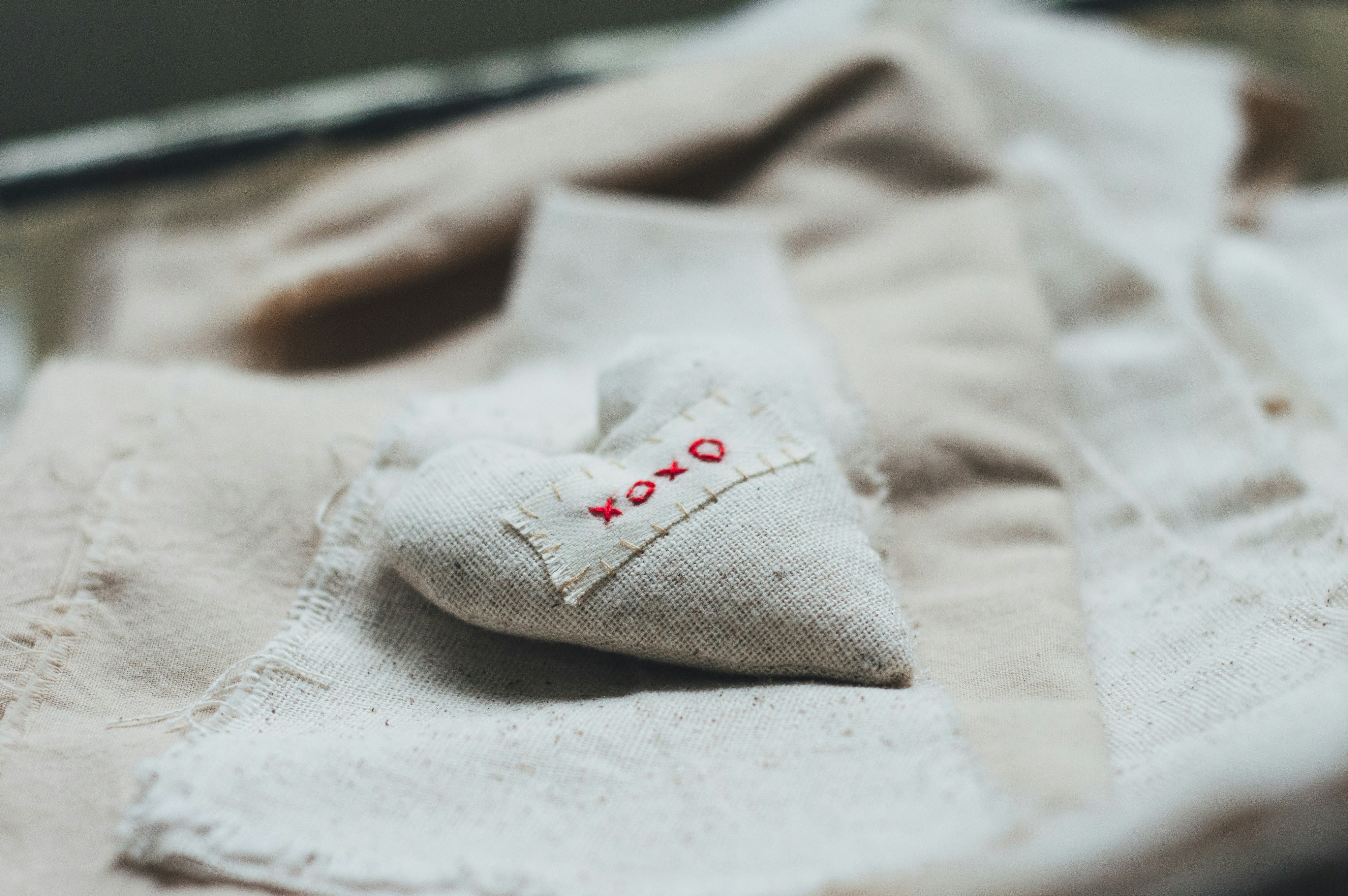a heart shaped pillow sitting on top of a bed