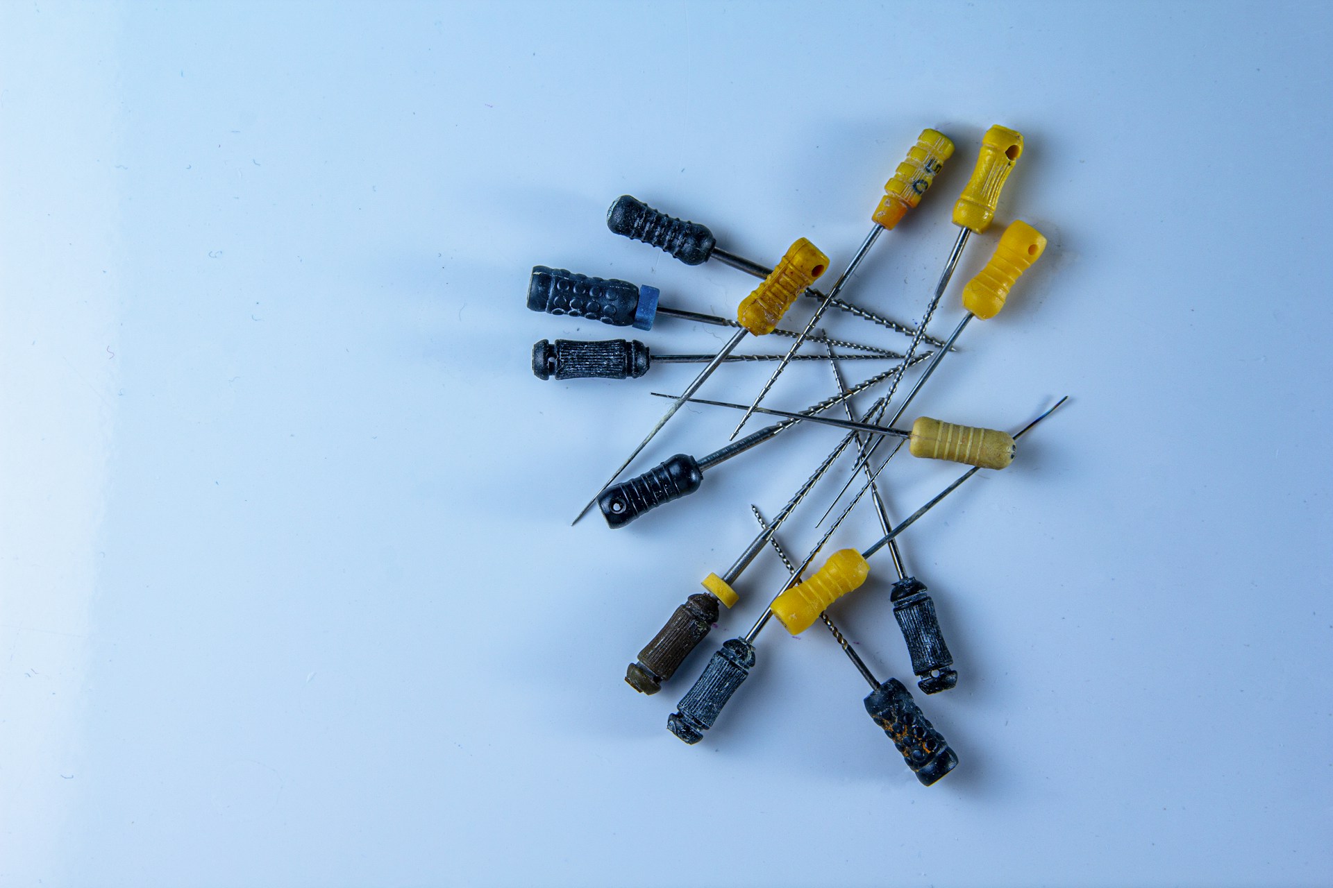 a bunch of small yellow and black toothpicks on a white surface