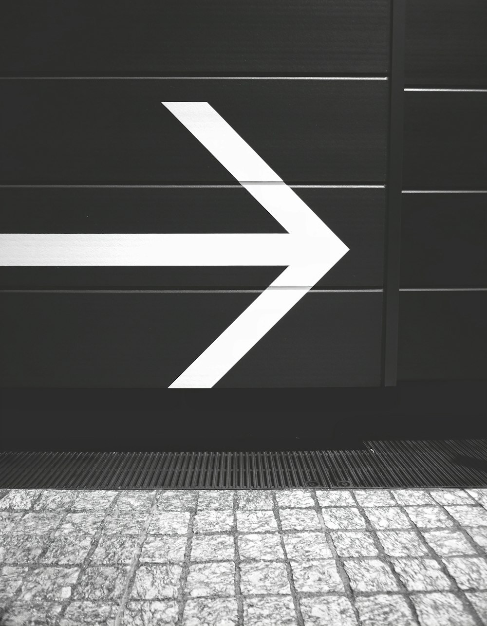 a black and white photo of an arrow sign
