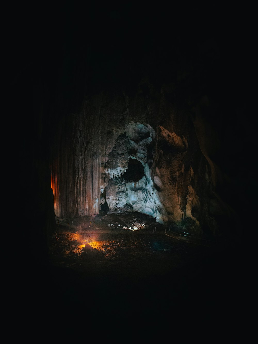 una grotta buia con un piccolo fuoco nel mezzo di essa