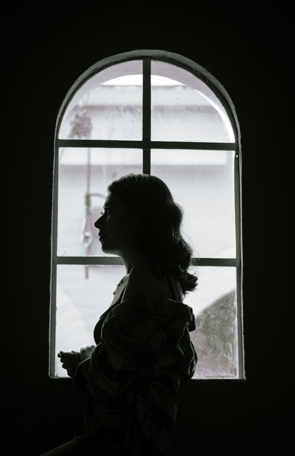 a woman standing in front of a window