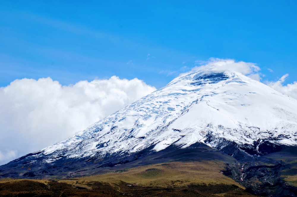 a large mountain covered in snow under a blue sky