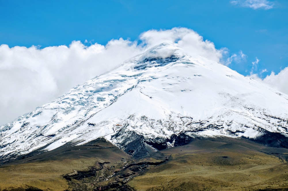 a large mountain covered in snow under a blue sky