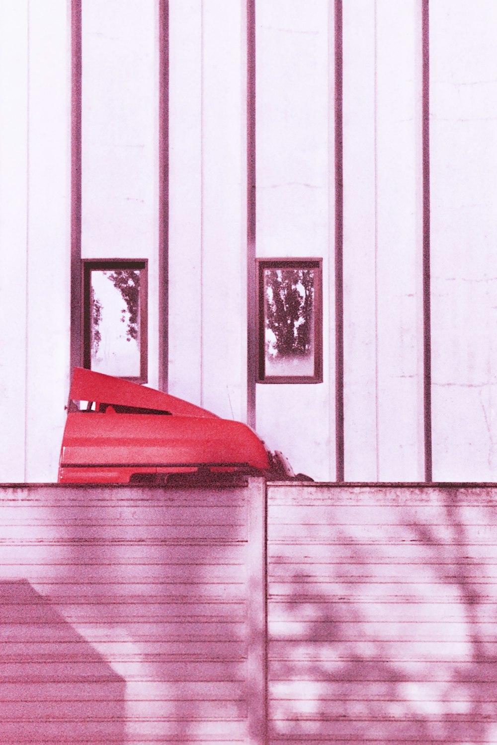 a red umbrella sitting on the side of a building