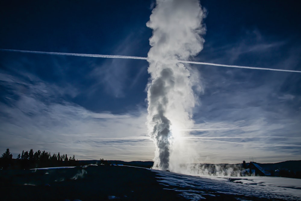 smoke coming out of the water with Old Faithful in the background