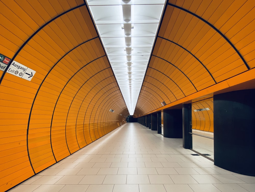 a long hallway with orange walls and a white floor