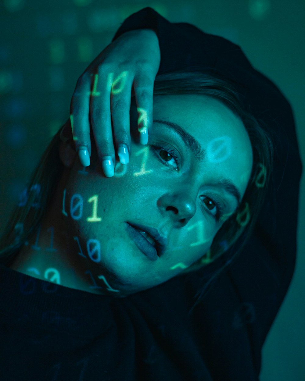 a woman in a black hoodie with numbers projected on her face