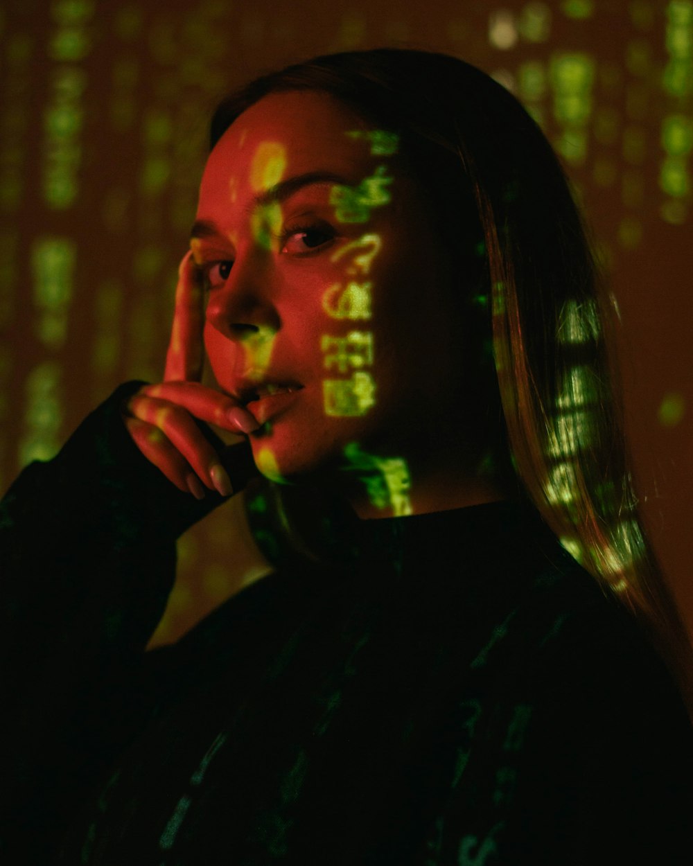 a woman in a black shirt is holding her hand to her face