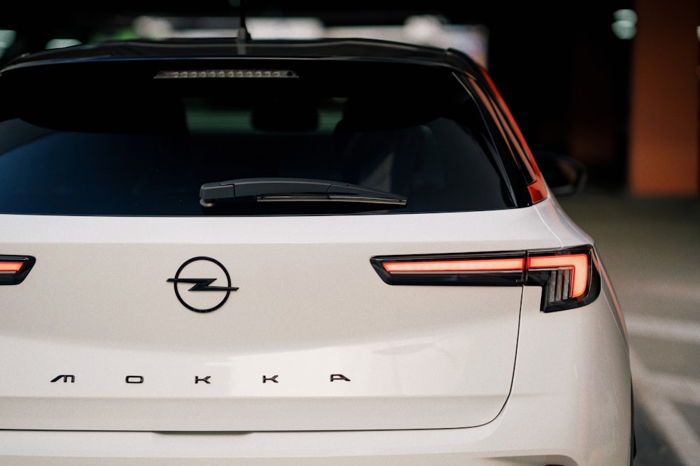 a close up of a white car parked in a parking lot