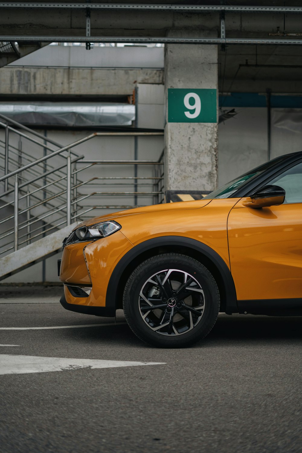 an orange car parked in a parking garage