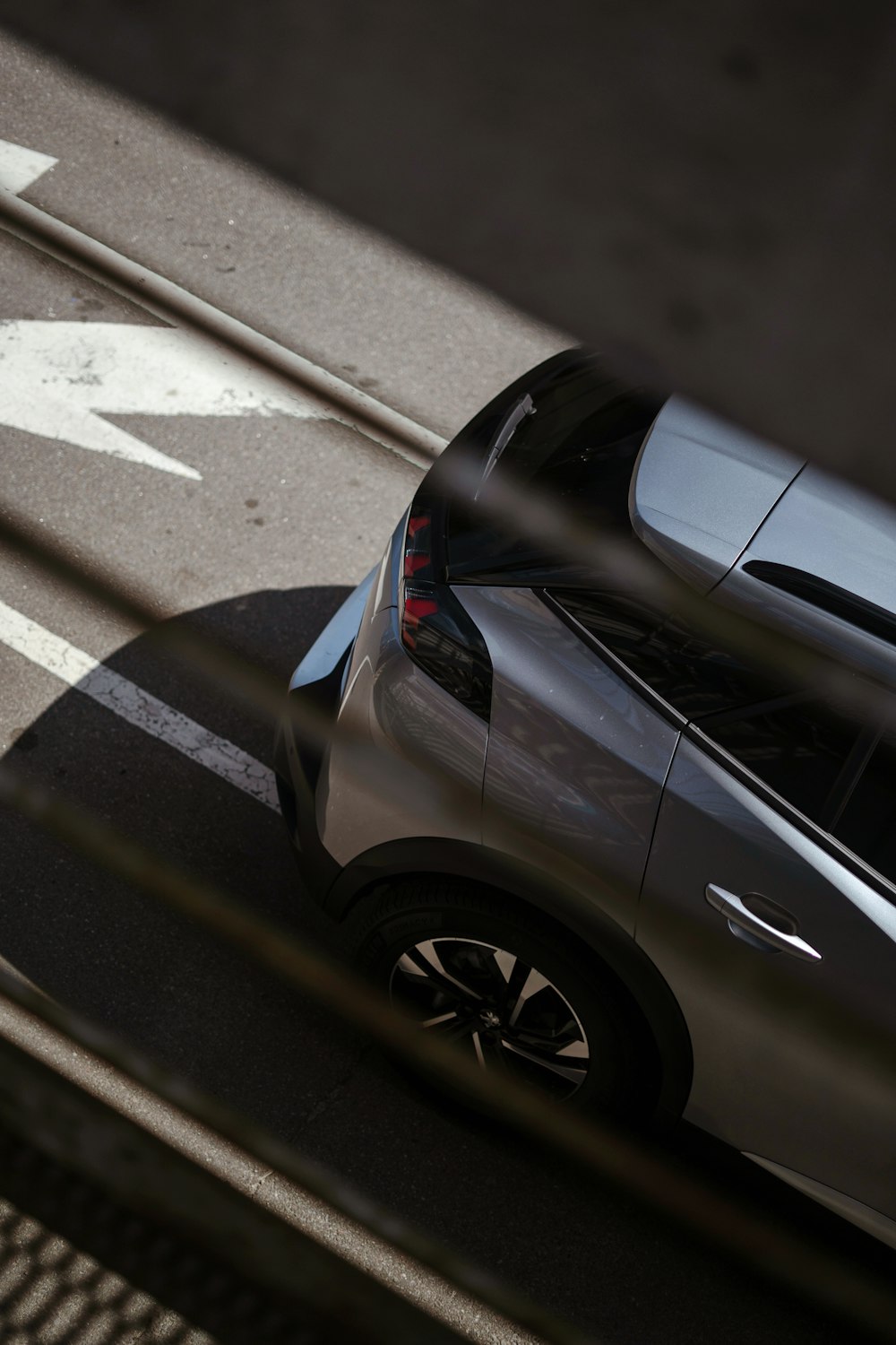 une voiture roulant dans une rue à côté d’un panneau de signalisation