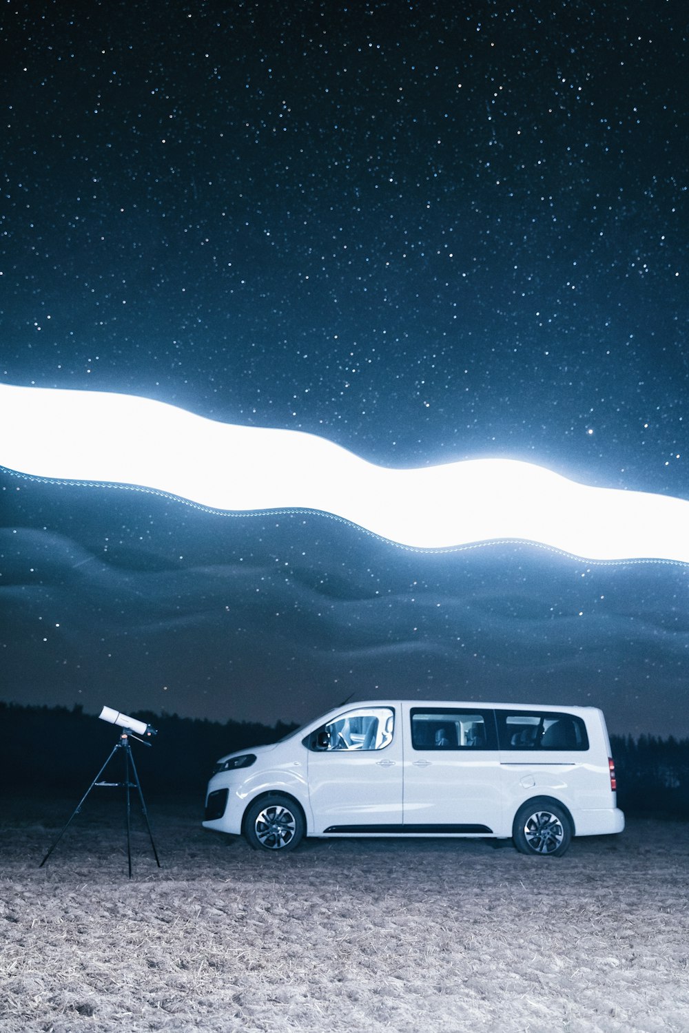 a van parked in a field under a night sky