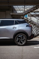 a silver car parked in front of a set of stairs