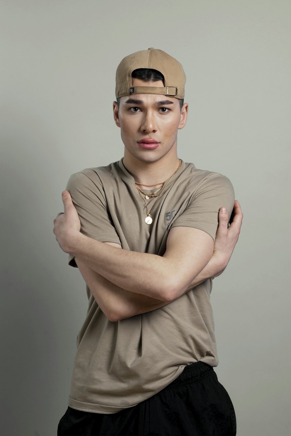 a young man with his arms crossed posing for a picture