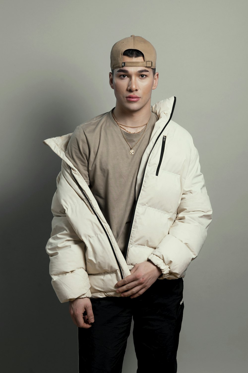 a young man in a white jacket and hat