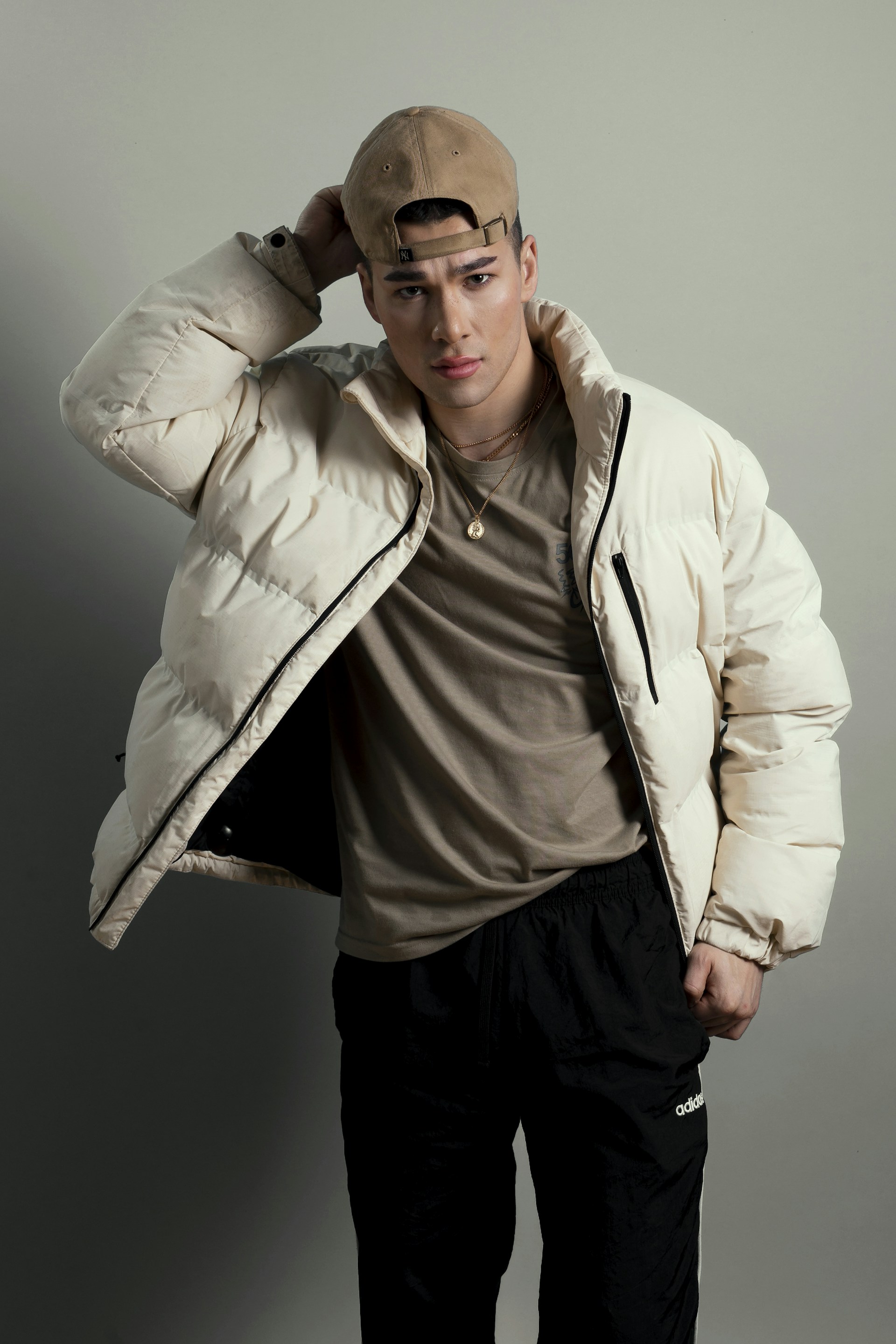 a man in a jacket and hat posing for a picture