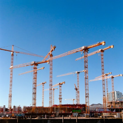 a bunch of cranes that are standing in the air