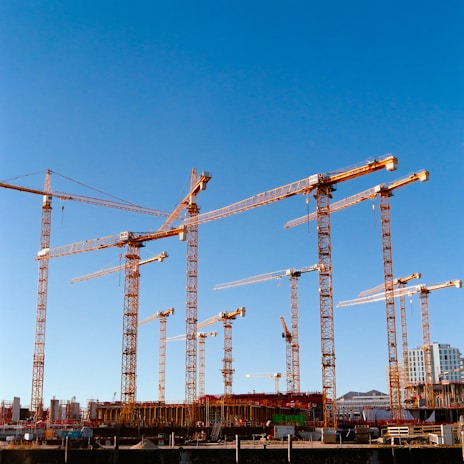 a bunch of cranes that are standing in the air