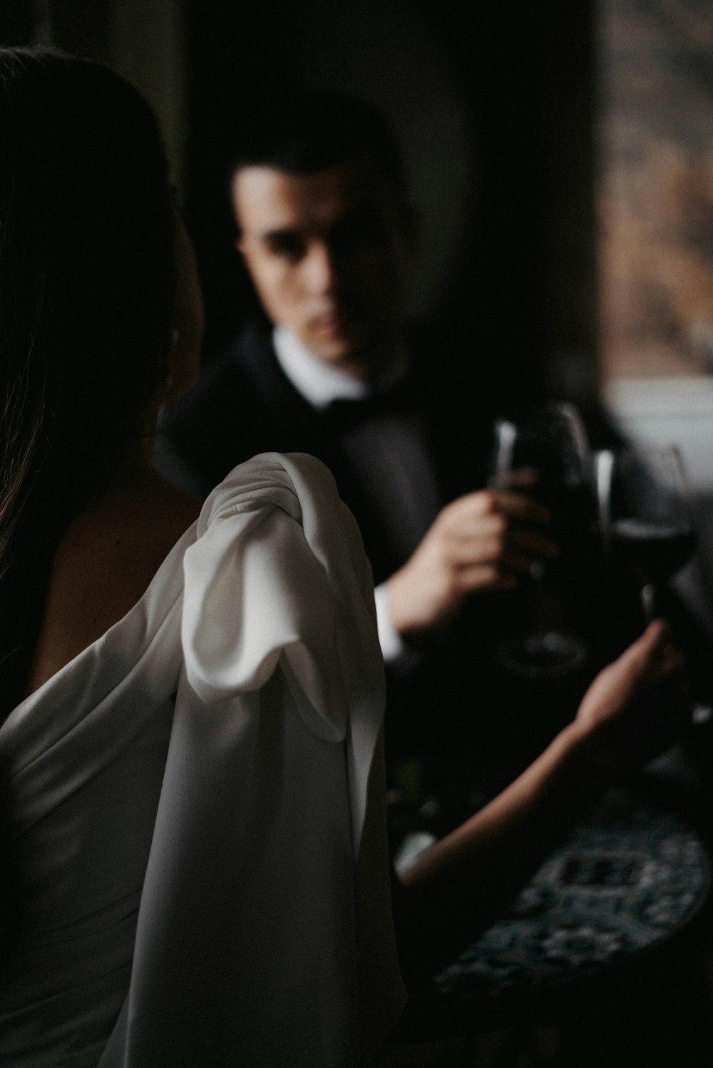 a man in a tuxedo standing next to a woman in a white dress