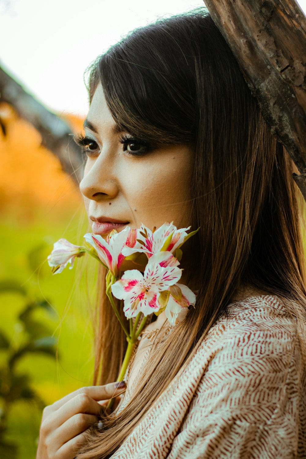 a woman with long hair holding a flower