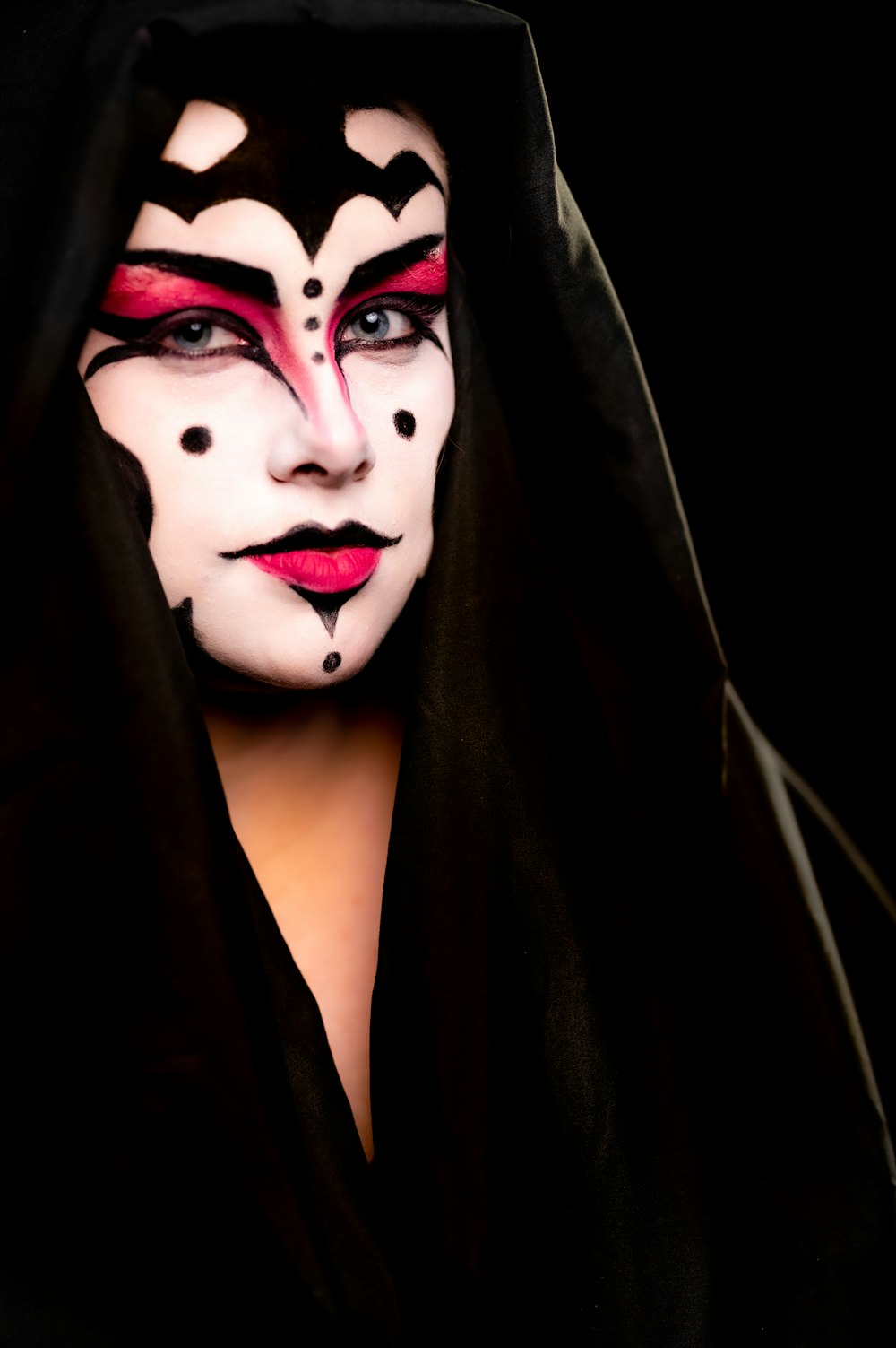 a woman with makeup on her face wearing a black robe